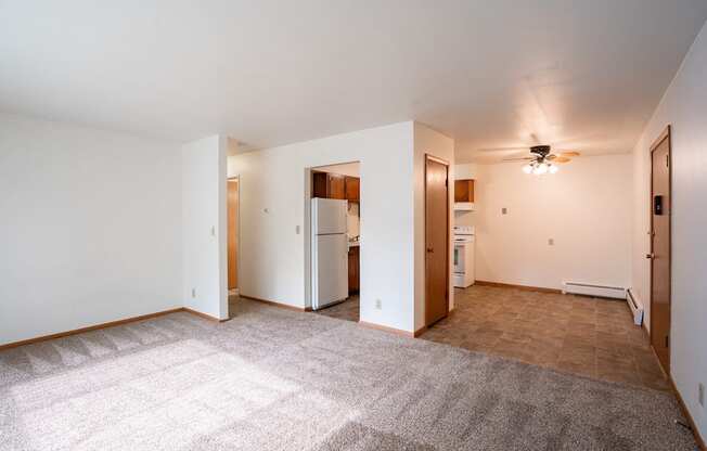 an empty living room with white walls and a ceiling fan. Fargo, ND Crown Court 1 Apartments