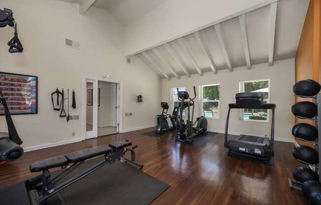 a home gym with a vaulted ceiling and hardwood flooring