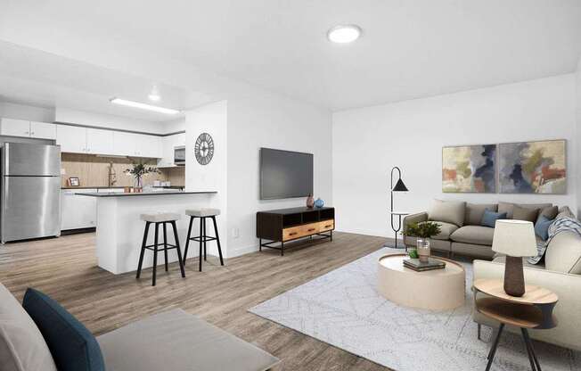 A modern living room with a kitchen area in the background.