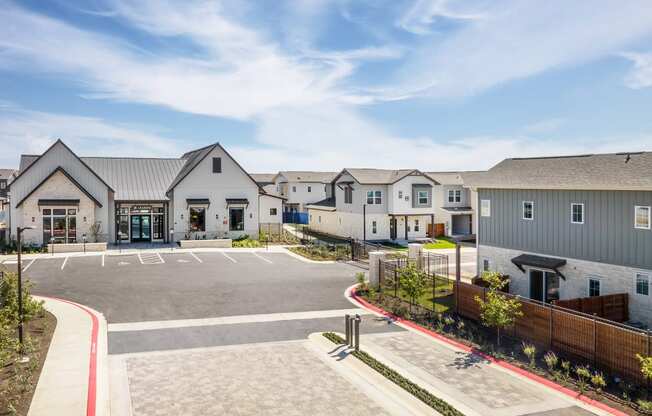 an empty parking lot in front of a row of houses