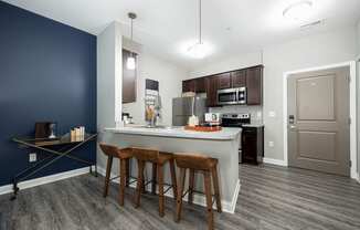 a kitchen with a large island with three stools