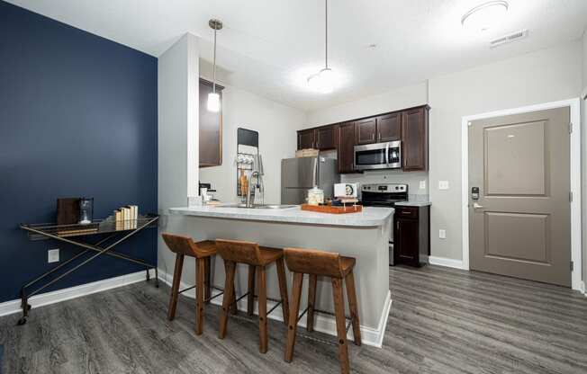 a kitchen with a large island with three stools