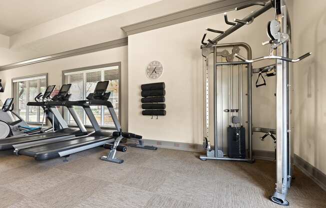 a gym with treadmills and weights in the corner of a room
