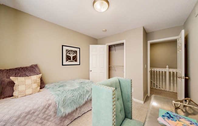 a bedroom with a bed and a chair and a closet