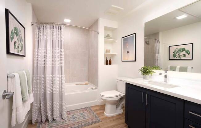 Stylish bathrooms feature large frameless mirrors, quartz countertops, modern cabinetry, and soaking tub with custom tile surround