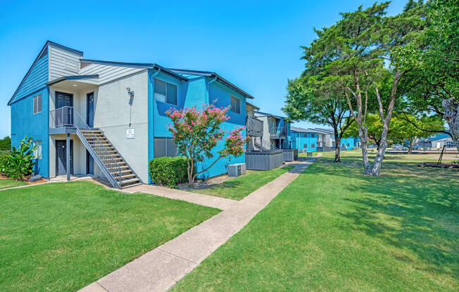 a row of colorful apartments with grass and trees