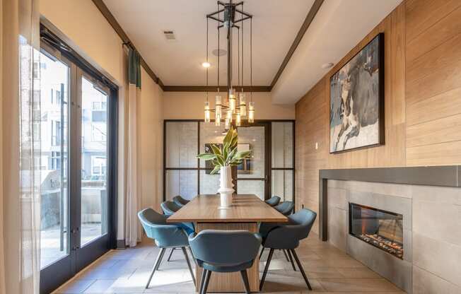 a dining room with a wooden table and chairs and a fireplace