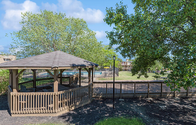 a gazebo in a park next to a tree