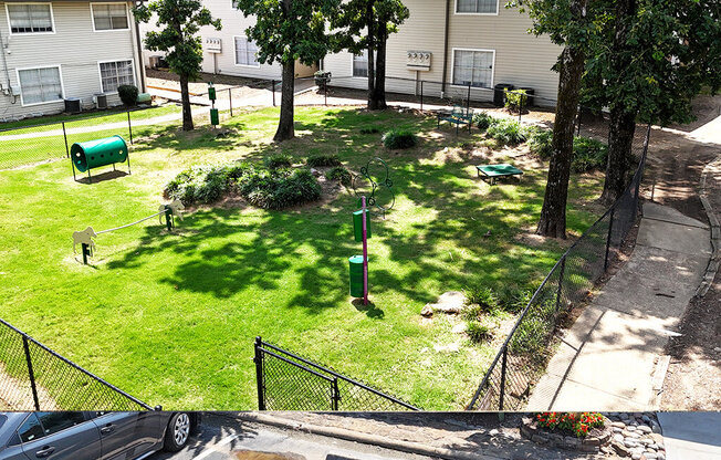 A green mailbox sits on a lawn in front of a house.