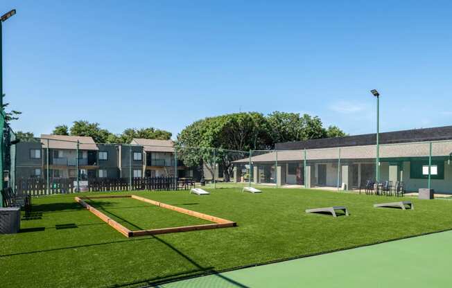 recreation lawn at fusion Fort Worth apartments in Haltom City, TX with corn hole and patio furniture