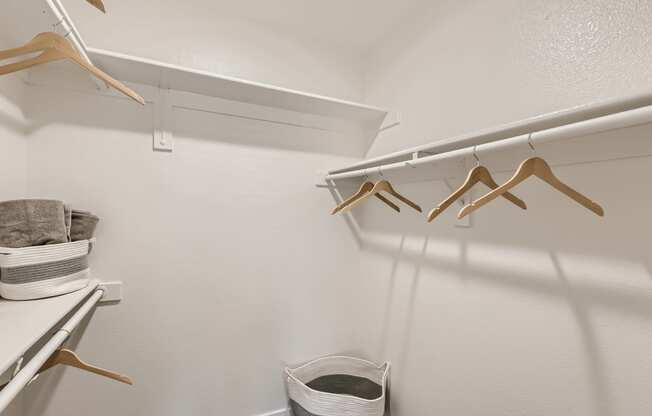 a walk in closet with a hanger and a basket