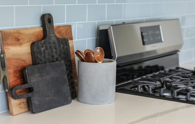 a kitchen with a stove top oven next to a wooden chopping board