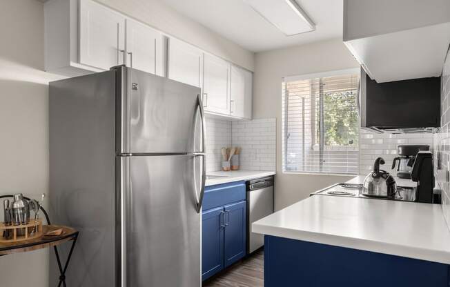 a kitchen with white countertops and blue cabinets