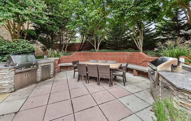 A patio with a table and chairs surrounded by trees.