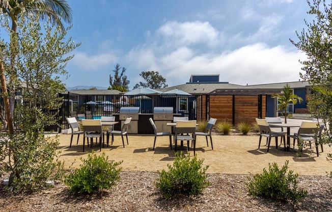 a patio with tables and chairs and a building in the background