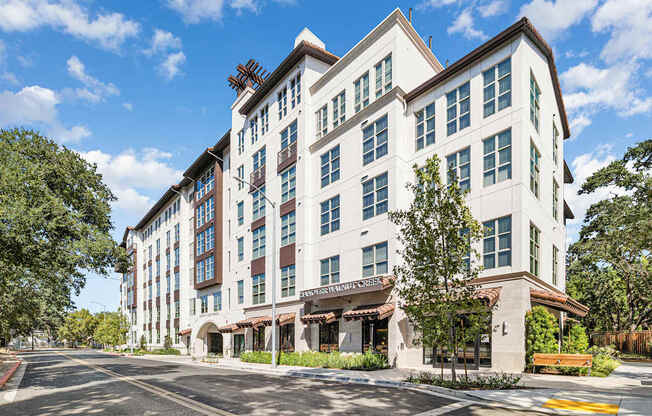Exterior view of luxury apartment community with modern design and tree-lined sidewalks