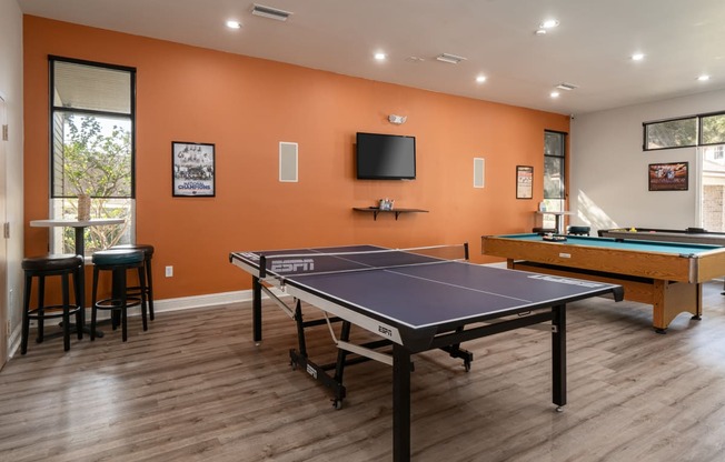 redesigned game room with two pool tables and a tv