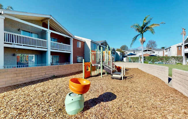 A playground with a slide and a green toy in the foreground.