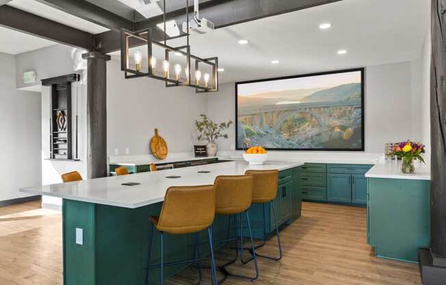 the kitchen has a large island and a large picture on the wall