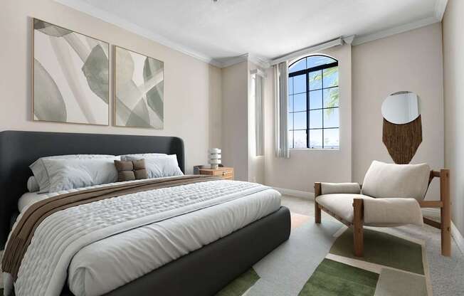 A bedroom with a large bed and a chair.