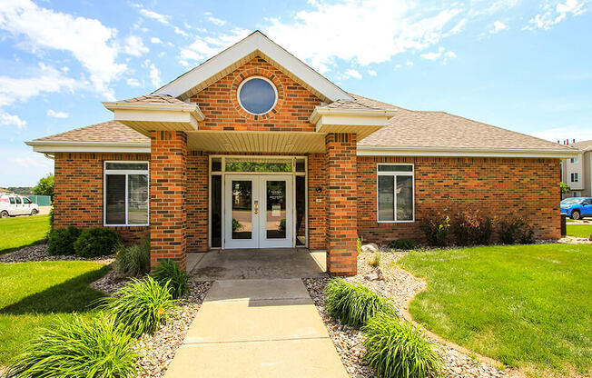 the front of a brick house with a walkway leading to the front door