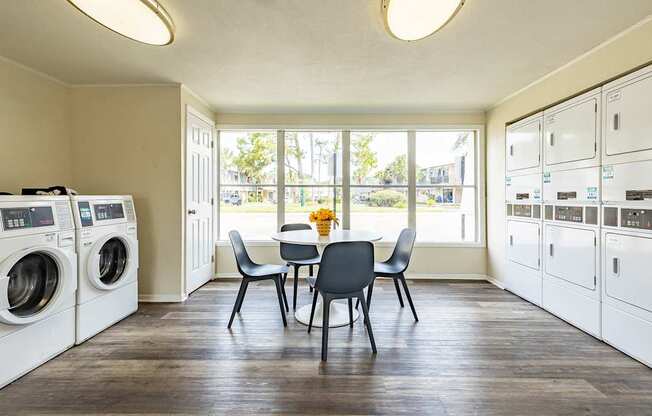 A laundry room with a table and chairs in the middle.