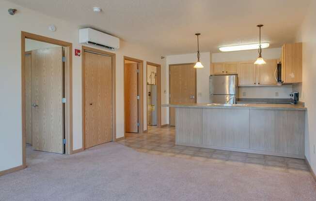 A kitchen area with a refrigerator, cabinets, and a countertop.