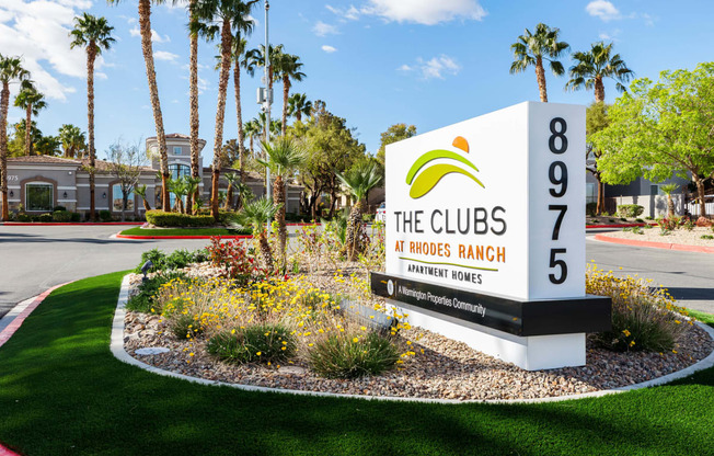 the clubs at hoses ranch sign in front of lawn and palm trees