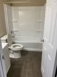 a white bathroom with a toilet and a tub