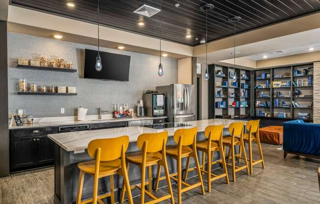 a kitchen with a bar and yellow chairs