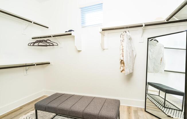 A spacious closet with built-in shelving and hanging space offers an organized layout designed to keep daily essentials neatly in place.