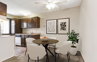 Georgetown on the River Apartments, Fridley, MN. a dining area with a table and chairs and a kitchen in the background