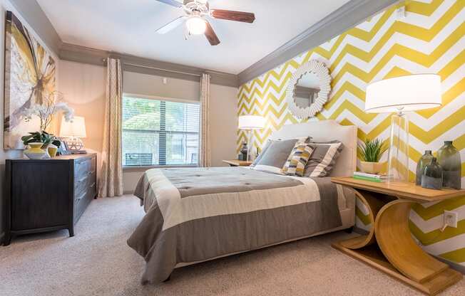 A bedroom with a bed, nightstand, and a ceiling fan.