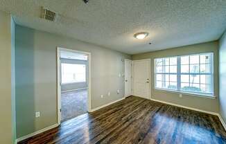 the living room and dining room of an empty house with wood floors