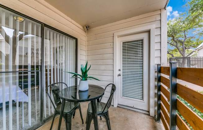 a patio with a table and chairs and a sliding glass door