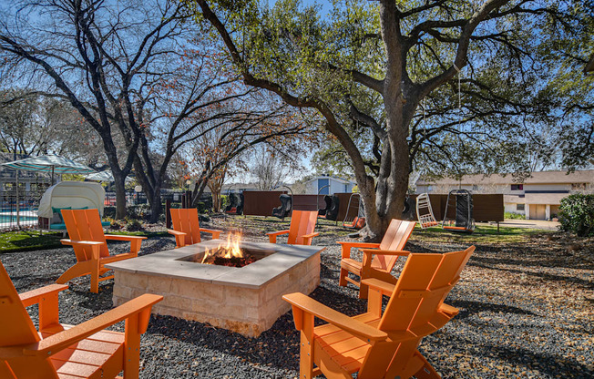 a group of orange chairs around a fire pit
