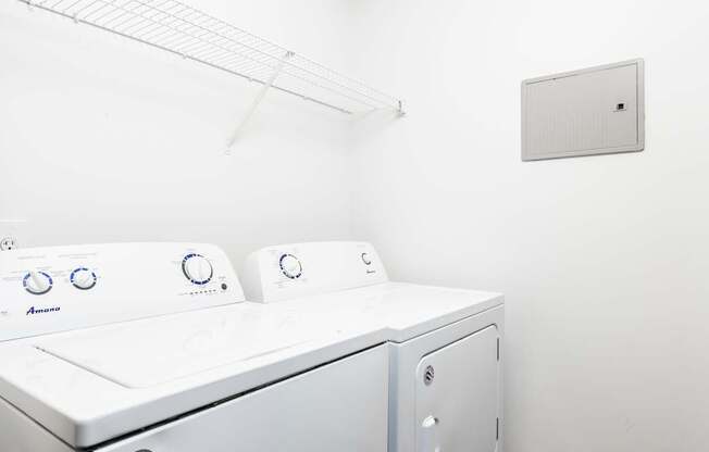 A white washing machine in a laundry room at The Palms at Chatham apartments in Savannah GA.