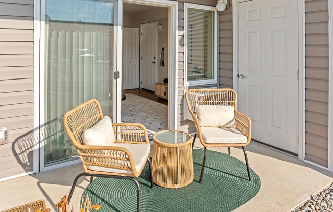 Two chairs and a table are on a patio.