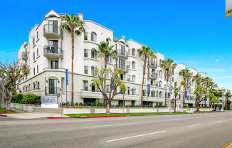 a white building with palm trees in front of a street at Burton, Los Angeles, California