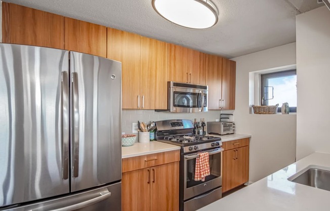 kitchen with brown cabinets, white countertops and stainless steel oven and microwave