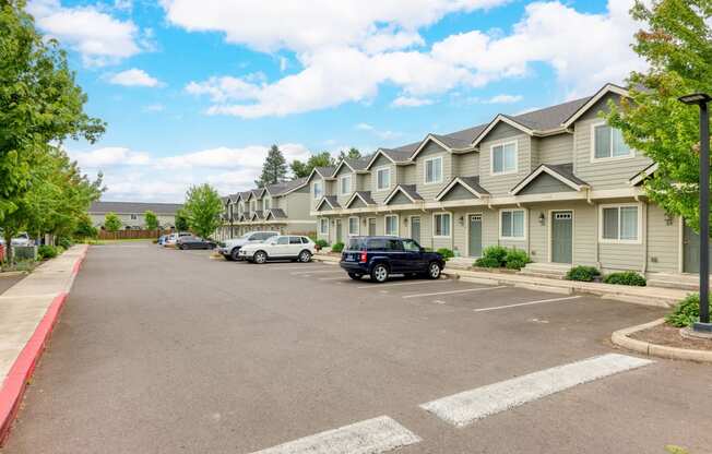 a parking lot with cars parked in front of apartment buildings