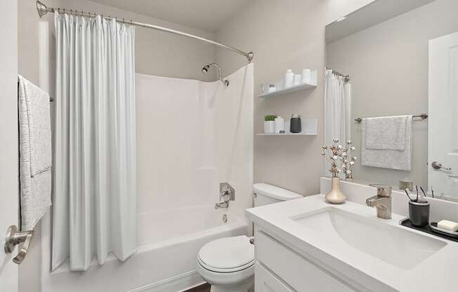 Model Bathroom with White Cabinets, Wood-Style Flooring and Shower/Tub at Colonnade at Fletcher Hills Apartments in El Cajon, CA.