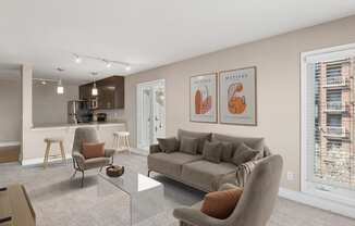 a living room with a couch coffee table and chairs and a kitchen in the background