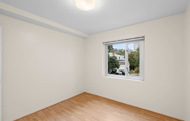 a room with white walls and a window and a wooden floor