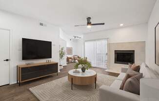 A modern living room with a flat screen TV, a fireplace, and a ceiling fan.
