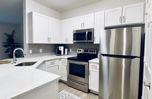 kitchen with stainless steel appliances and white cabinets at Mainstreet Apartments, Florida