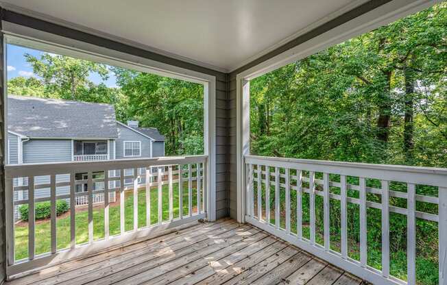 a balcony with a view of a house and trees