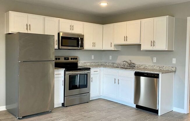 a kitchen with stainless steel appliances and white cabinets