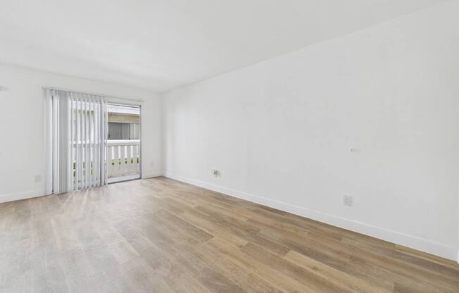 A room with a sliding door and wooden flooring.