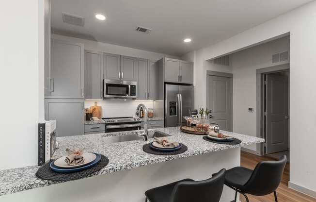 a kitchen with granite counter tops and a island with plates of food